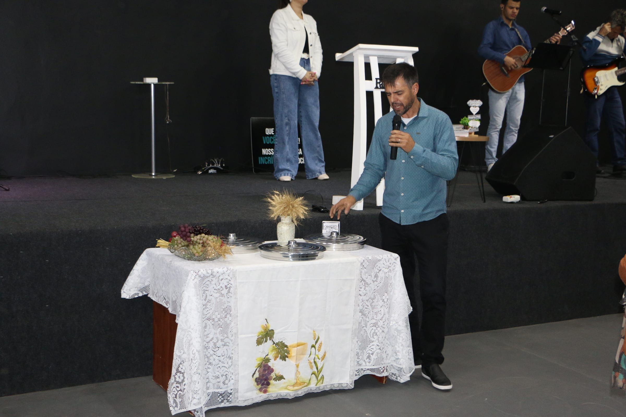 Mesa da ceia posta diante do palco durante um culto.