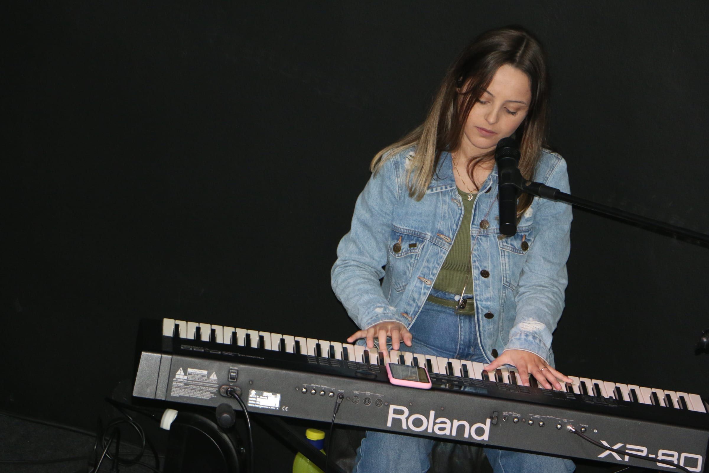 Jovem tocando teclado durante o louvor.
